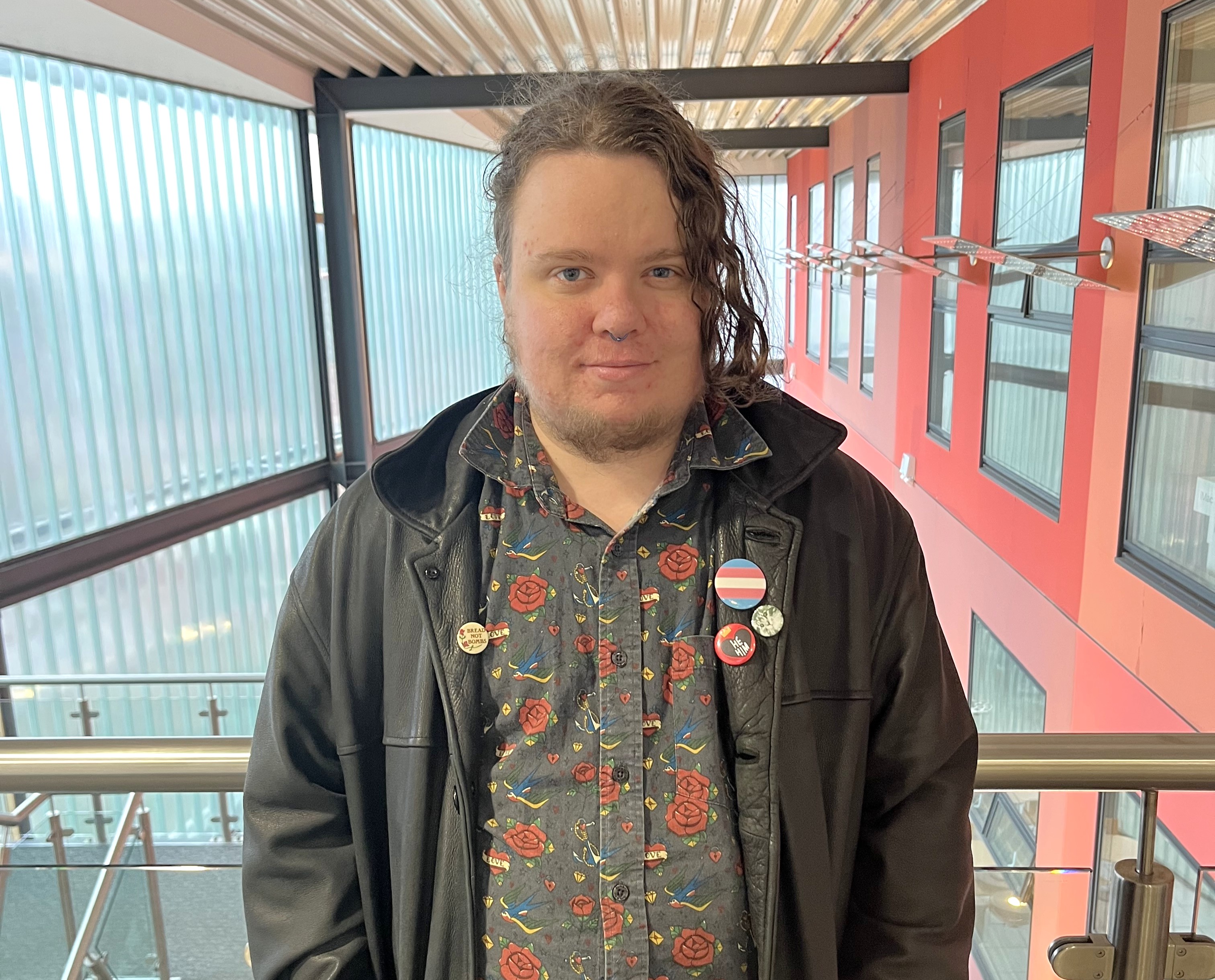 A person stood smiling in an indoor setting