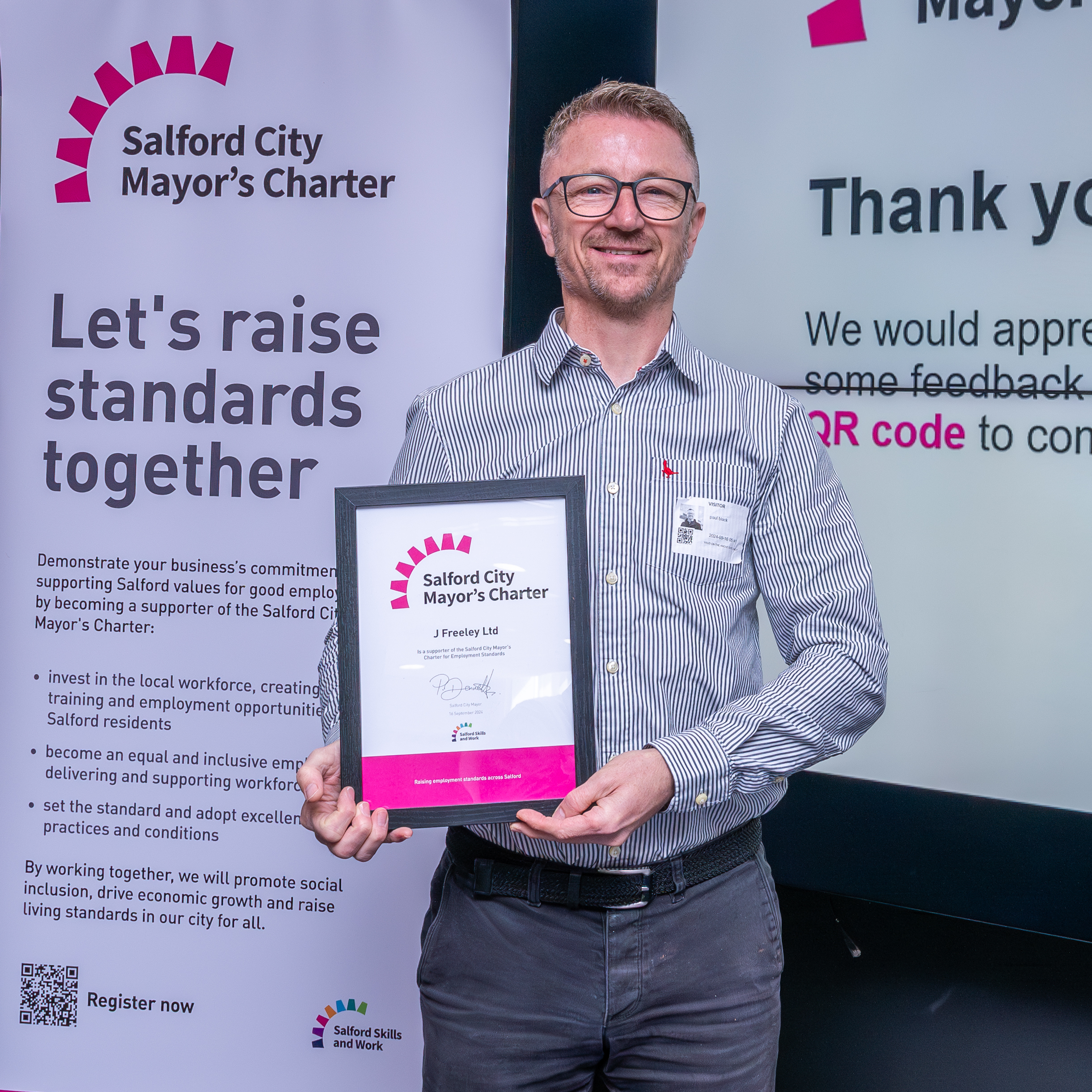 A man holding a Salford City Mayor's Charter award