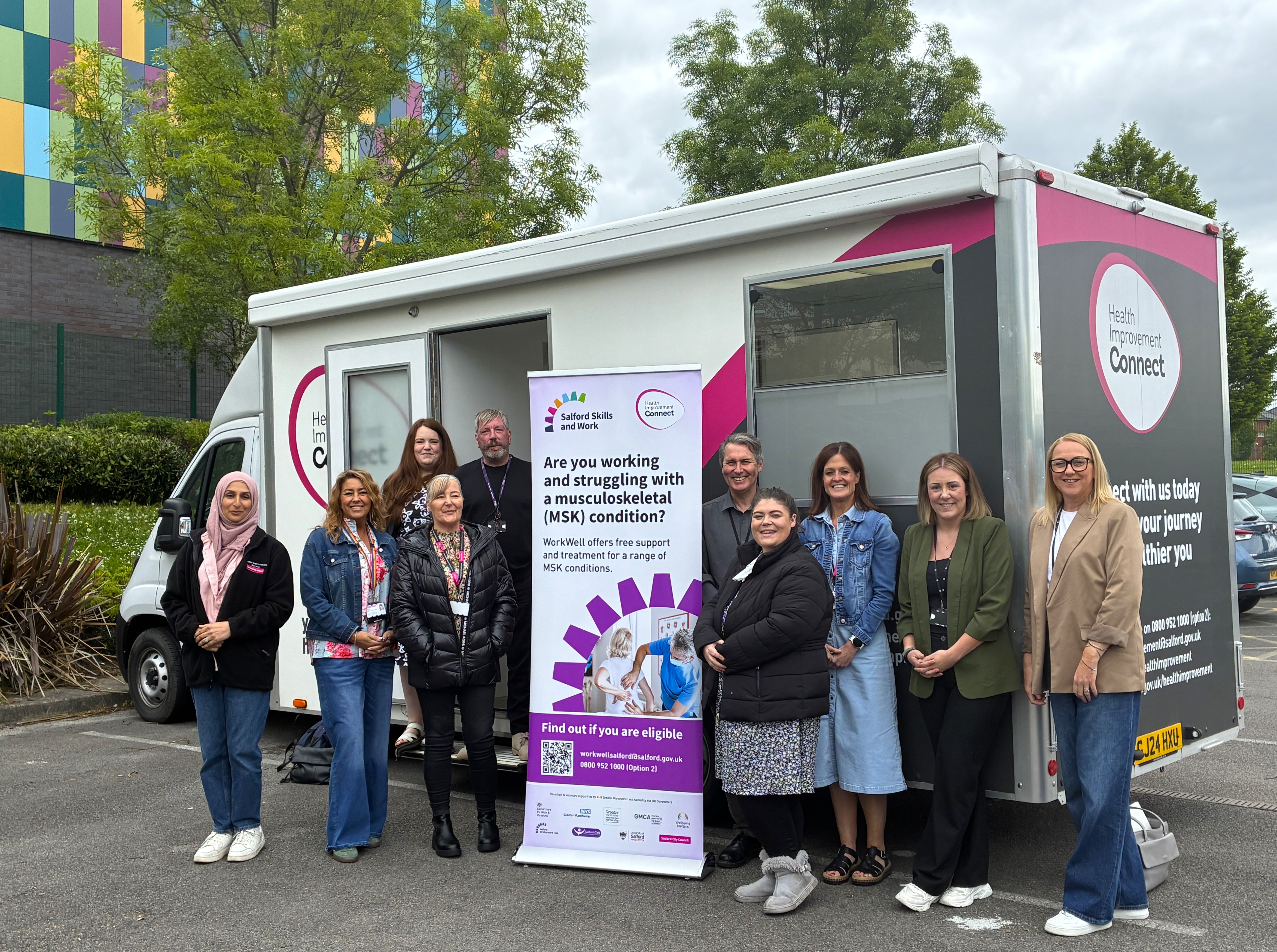 A group of people smiling next to a van