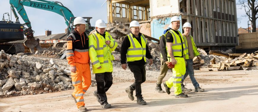 A group of construction workers wearing high visibility clothing and hard hats