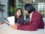 A man and woman sat at a desk in an office
