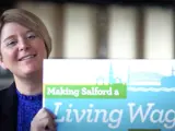 A woman holding a sign saying: Making Salford a Living Wage