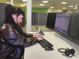 A young woman sat at a desk working on a computer