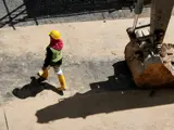Construction worker walking past a digger