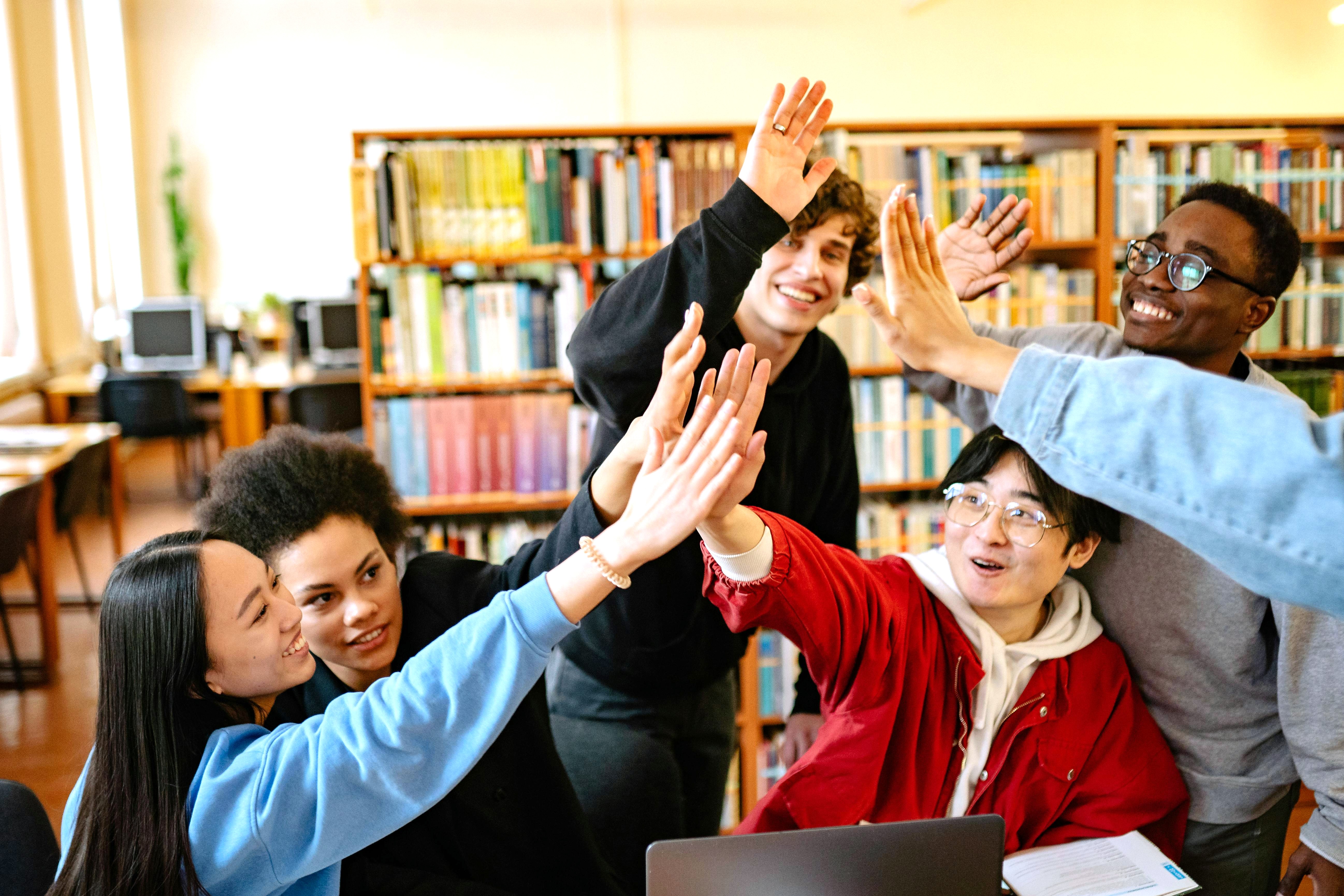 A group of children giving high fives to each other in the library