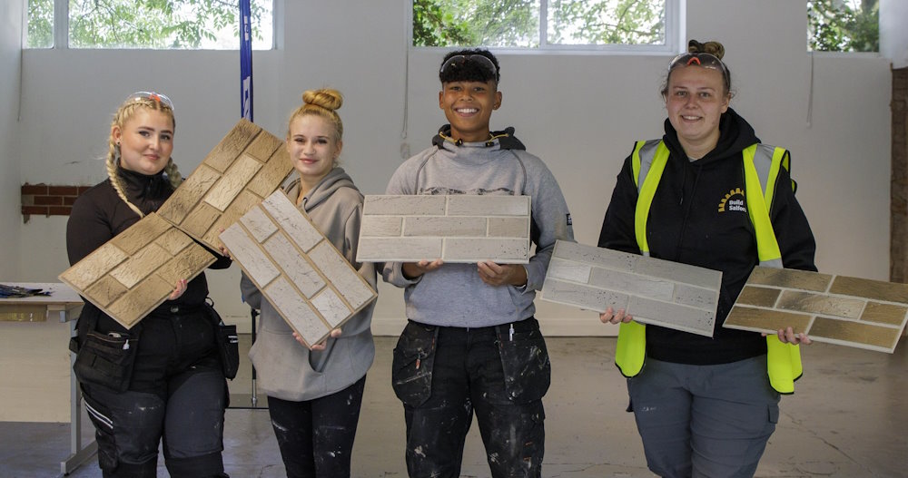 Four of the students at the Peel Green Skills Centre holding tiles